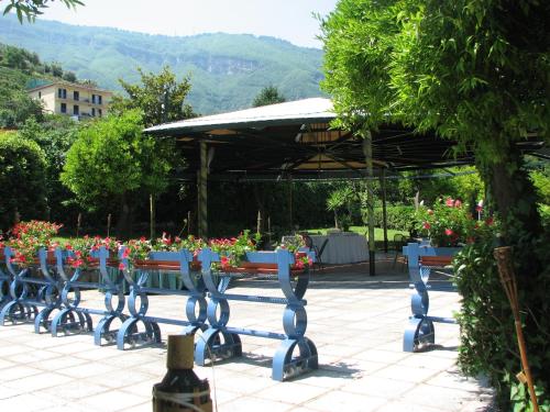 a bench with flowers on it in a park at Hotel Parco in Castellammare di Stabia