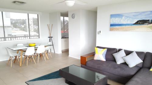a living room with a couch and a table at Wyuna Beachfront Holiday Apartments in Gold Coast