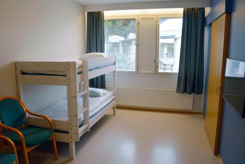 een kamer met een stapelbed, een stoel en een raam bij Spa Hostel Kunnonpaikka in Kuopio