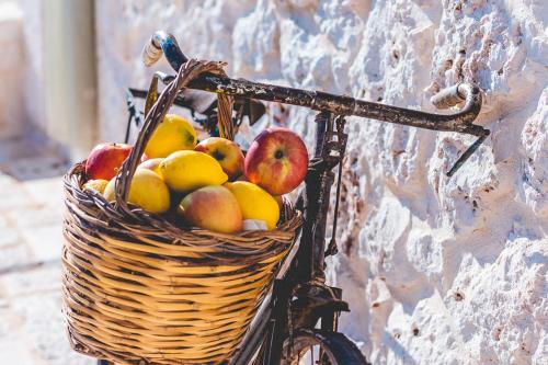 a basket of fruit on a bicycle against a wall at Materiis in Noci