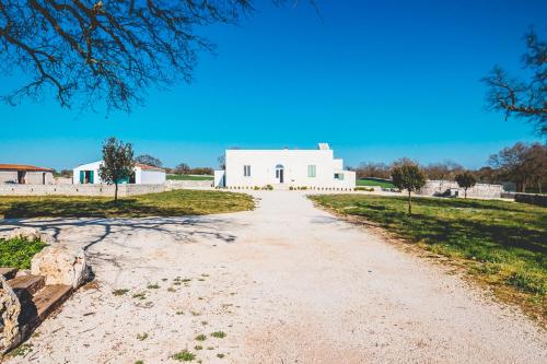 a dirt road in front of a white building at Materiis in Noci