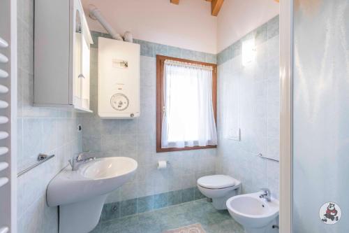 a white bathroom with a sink and a toilet at RESIDENCE-HOTEL CIMBRO in Mezzaselva