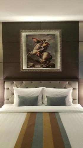 a bedroom with a large bed with a painting above it at Gallery Design - SHA Extra Plus in Si Sa Ket