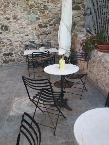 a group of tables with chairs and an umbrella at Pension Anapli in Nafplio