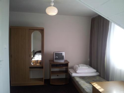 a hotel room with a bed and a tv at Zajazd Galicja in Dukla