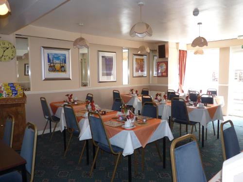 een restaurant met tafels en stoelen in een kamer bij The Avon in Blackpool