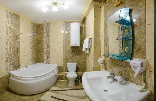 彼得巴甫洛夫斯克的住宿－Ghostinitsa "Lina"，浴室配有盥洗盆、卫生间和浴缸。