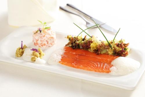 a plate of food with salmon and other foods at Hotel Restaurant Alatsee in Füssen