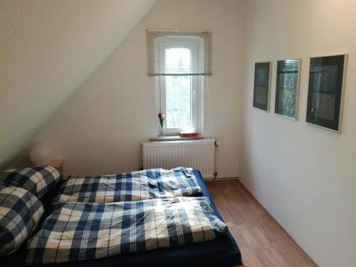 Schlafzimmer mit einem Bett und einem Fenster in der Unterkunft Apartment Wuelfel in Hannover