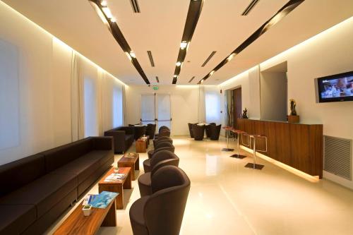 a living room with couches and a flat screen tv at Card International Hotel in Rimini