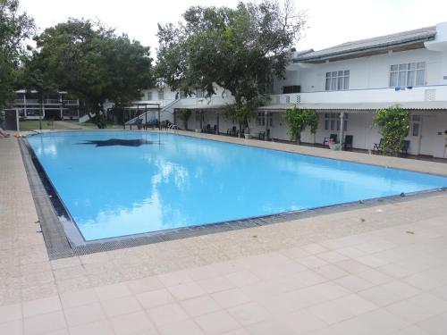 a large blue swimming pool in front of a building at Pigeon Island Beach Resort in Nilaveli