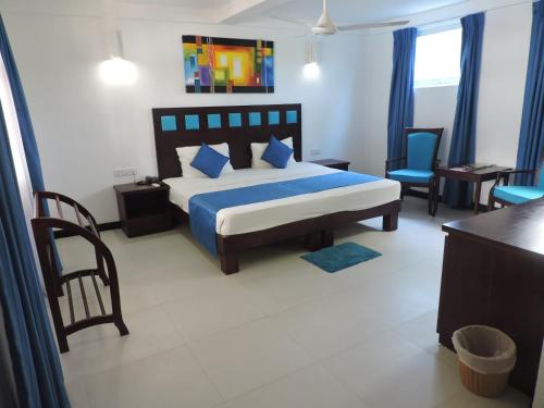 a hotel room with a bed and a desk at Pigeon Island Beach Resort in Nilaveli