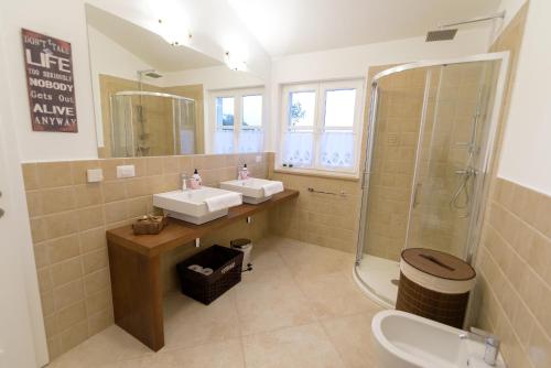 Sveti Lovreč PazenatičkiにあるVilla Rajski Dvoriの洗面台2つとシャワー付きのバスルーム