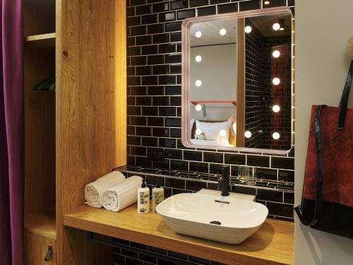 a bathroom with a sink and a mirror at 25hours Hotel Langstrasse in Zurich