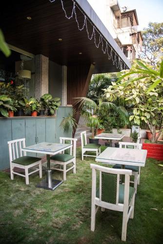 a group of tables and chairs sitting on the grass at Hotel Oriental Aster - Mumbai International Airport in Mumbai