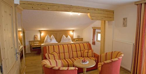 pokój hotelowy z łóżkiem, stołem i krzesłami w obiekcie Herzoghof w mieście Leogang