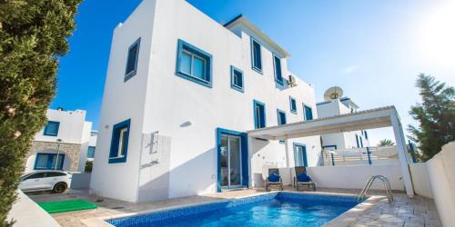 a white house with a swimming pool in front of it at Sea View Villa Paralimni in Paralimni