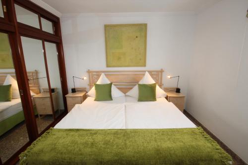アルカラにあるCasa Business Finca Alcaláのベッドルーム(緑の枕が付く大きな白いベッド付)