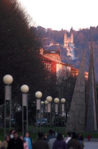 people walking in a park with a castle in the background at Hotel do Elevador in Braga