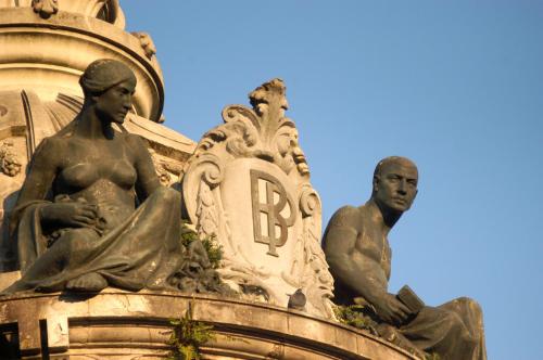 two statues of women sitting on top of a building at Hotel do Elevador in Braga