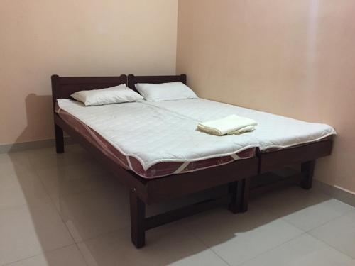 a bed with two pillows on top of it at Mega Tourist Home Palarivattom in Cochin