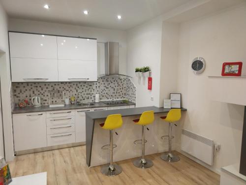 a kitchen with two yellow stools at a counter at Studio apartment Arija in Zagreb