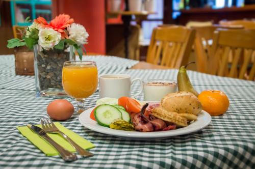 a plate of food on a table with orange juice at Spa Hostel Kunnonpaikka in Kuopio