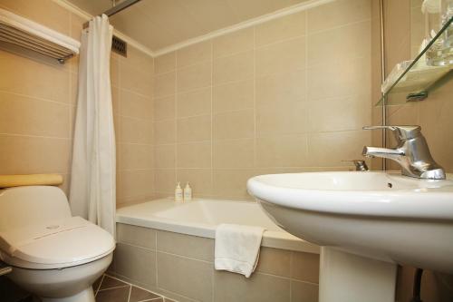 a bathroom with a sink and a toilet and a tub at Savoy Hotel Myeongdong in Seoul