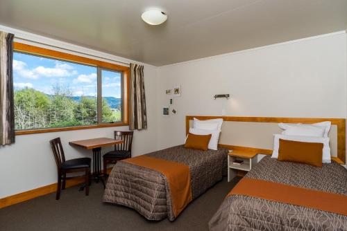 a hotel room with two beds and a window at Eden's Edge Lodge in Motueka