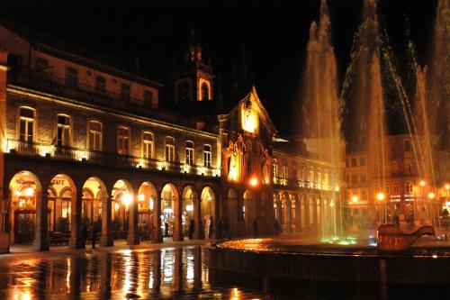 a fountain in front of a building at night at Hotel do Lago in Braga