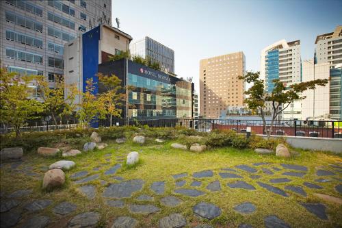 a park in the middle of a city with buildings at Savoy Hotel Myeongdong in Seoul