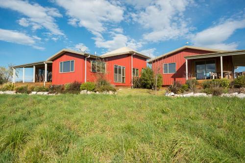 two houses in a yard with a grass field at Eden's Edge Lodge in Motueka