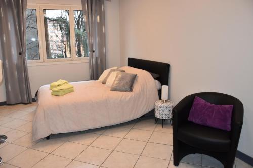 - une chambre avec un lit et une chaise dans l'établissement La Forclaz, à Annecy