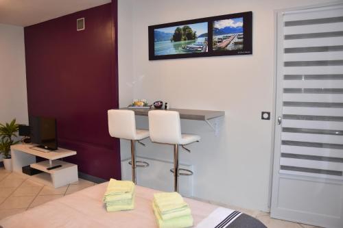 - une chambre avec un bureau et un lit avec deux chaises blanches dans l'établissement La Forclaz, à Annecy
