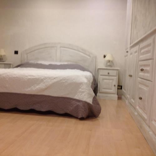 une chambre avec un lit blanc et une table de chevet dans l'établissement Maison Joge, à Gassin