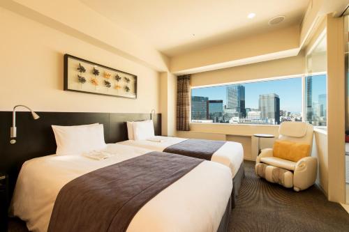 a hotel room with two beds and a window at remm Akihabara in Tokyo