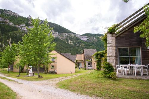 a country house in the mountains with a gravel road at Village de gîtes de Blajoux in Quézac