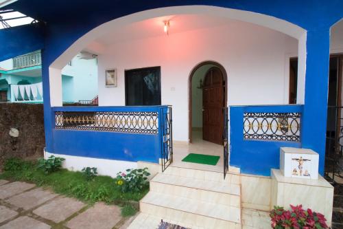 a house with blue and white walls and a door at Brittos Homestay in Mandrem