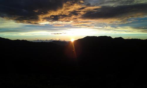 a sunset over the mountains with the sun setting at Cingjing Brilliant Twins of Seattle in Renai