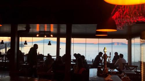 a group of people sitting in a restaurant looking at the view at Miro Mara Boutique Hotel & Lounge Bar in Edremit