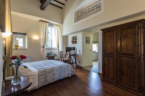 a bedroom with a bed and a table with flowers on it at Abbazia Collemedio Resort & Spa in Collazzone