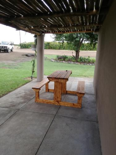 a wooden picnic table sitting on a patio at Elim Guesthouse in Keimoes