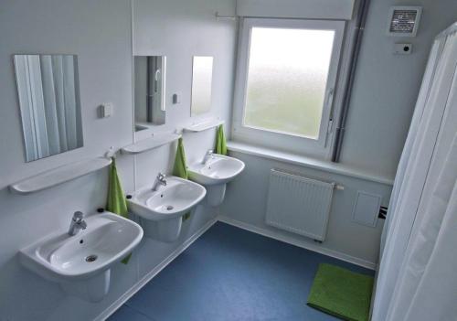 un baño con dos lavabos y dos inodoros en Hostel Września, en Września