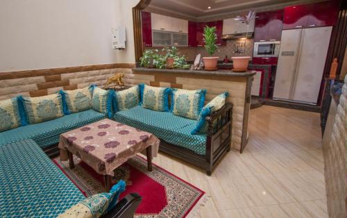 a living room with a couch and a table at Umbrella Holidays l 1Bd room l in Dcheira El Jihadia