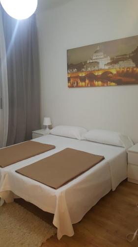 a bedroom with a white bed with a painting on the wall at Pension Yna Holiday in Málaga