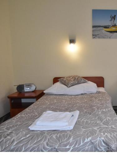 a hotel room with a bed with a towel on it at Hotel *** NAT Kołobrzeg in Kołobrzeg