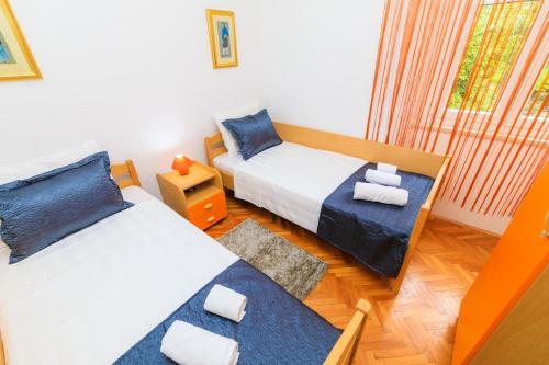 a small room with two beds and a window at Holiday Home Obrov in Kaštela