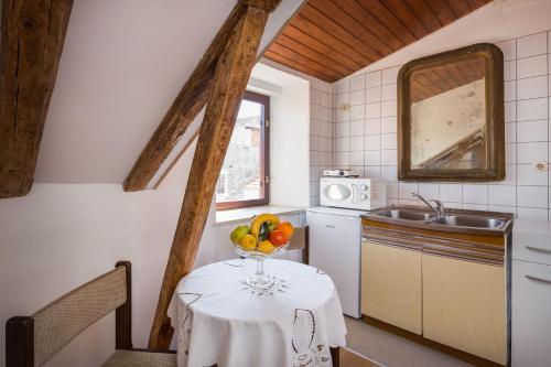 a kitchen with a table with a bowl of fruit on it at Apartment Patricia in Trogir