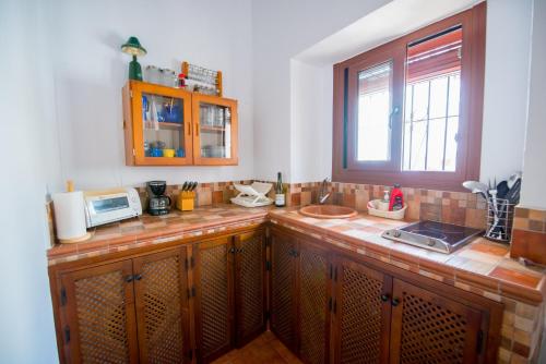 Kuchnia z oknem i blatem z kuchenką mikrofalową w obiekcie Casamonteymar Oliva w mieście Vejer de la Frontera