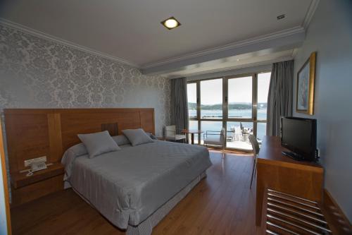 1 dormitorio con 1 cama y TV de pantalla plana en Hotel As Brisas do Freixo, en O Freixo